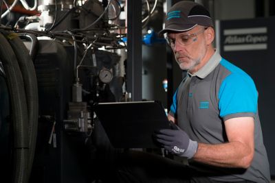 Male service technician in a working environment holding a tablet or pc