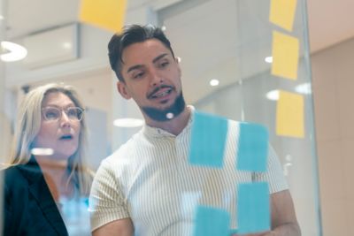 Employees having a conversation in front of post-its. 