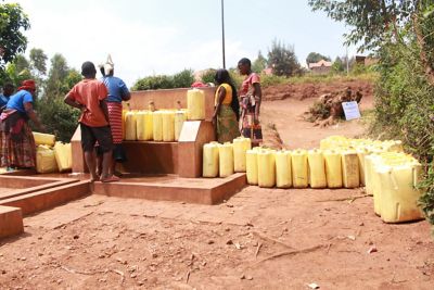 People gathered around a water tap outside.