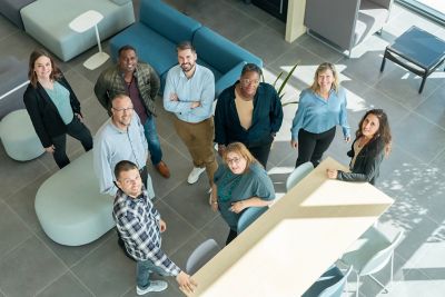 A group of employees smiling and standing confidently. 