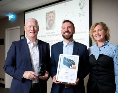 Victor Ghete en su día de graduación con los representantes del área de negocio, Andrew Walker y Marina Zinchenko.