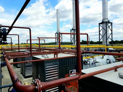 A large industrial facility with several industrial rental boilers. The machines are connected to each other with pipes. The facility is capable of delivering 60,000 kg of superheated steam per hour.