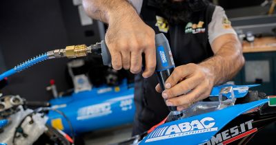 Man acting on motorbike with air compressor and drill