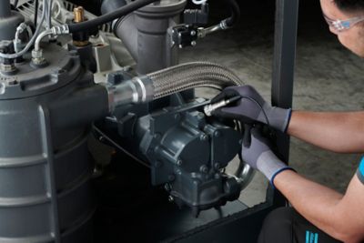 Hands of a service technicain putting the Airscan vibration measurement device on compressor element