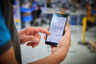 Atlas Copco service technician using ALTURE app in production