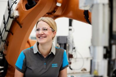 Atlas Copco technician smiling with flow-drill fastening equipment on the background
