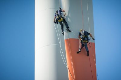 two operators sliding down a rappeler on a wind turbine