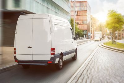 white van driving in city
