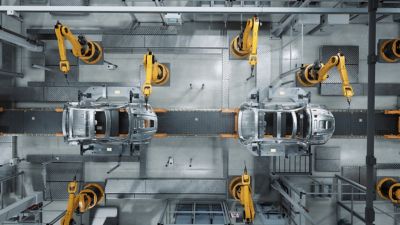 A factory line of cars with robots helping assemble the cars