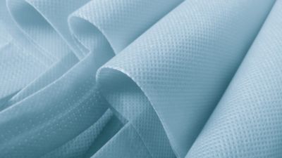 light blue polypropylene bag. non-woven fabric with wavy pleats. pile of environmentally friendly bag materials. spunbond bag