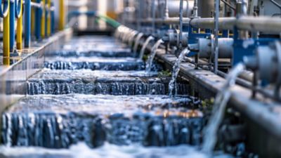 omplex machinery processes water in a modern wastewater treatment facility, showcasing advanced filtration technology in action under bright sunlight