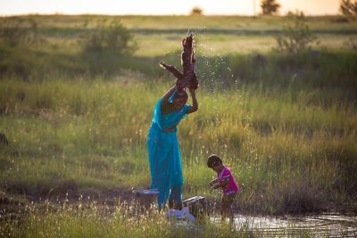 Beautiful woman with her child, washing in a natural spring. Project Jaldoot by Water for All India.