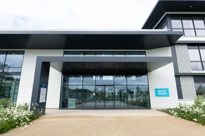Entrée du bâtiment Atlas Copco en France avec façade moderne et logo  visible.