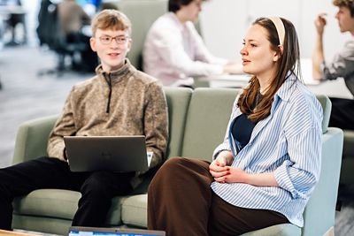 Image of two apprentices sat on a sofa having a conversation