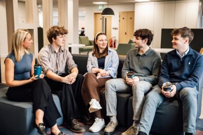 Young students engaging in a friendly conversation while seated in lounge