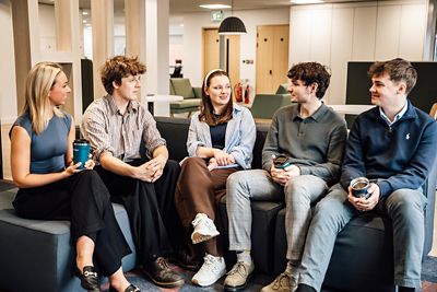 A group of employees sat together chatting 