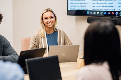 An employee smiling whilst in a meeting with colleagues