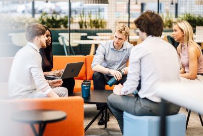 Office colleagues having an engaging discussion in a modern office space, fostering teamwork and communication.
