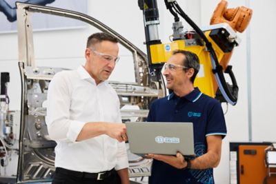 Employees discussing in front of a piece of equipment in the innovation center
