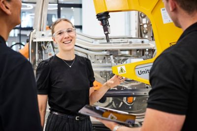 Employees discussing in front of a piece of equipment in the innovation center