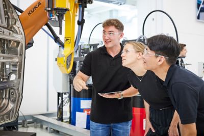 Employees taking a close look at a piece of equipment in the innovation center
