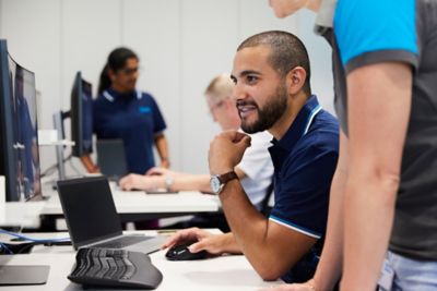 Employees in discussion at their workstations