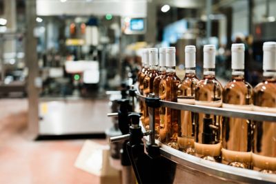 A row of wine bottles on a conveyor belt