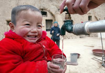Boy by water tap in China