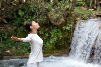 Beautiful girls are playing yoga at the park. Among the natural waterfalls in the forest, exercise concepts