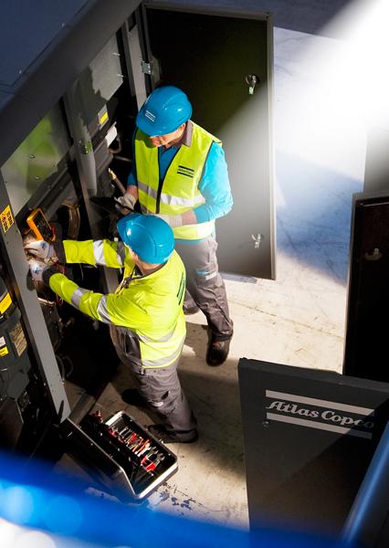 Atlas Copco service engineers doing preventive maintenance on air compressor