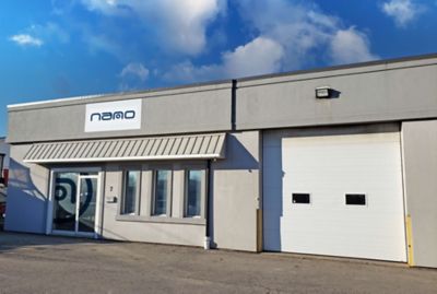 A small gray building with a garage on the right side, with a sign with the nano-purification solutions logo to convey our Canada location