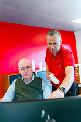 DANMIL employees in a conversation at the office.
