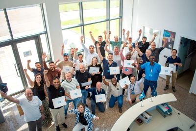 Participants of the Power Academy 2026 posing with their diplomas with the Portable Power and Flow representatives in a hall