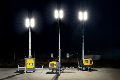 Atlas copco portable diesel-powered light towers illuminating a worksite at night with high-intensity LED floodlights.
