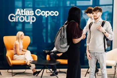Diverse employees engaged in conversation and networking in the office, promoting collaboration and teamwork.