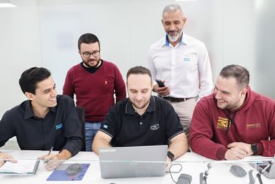 Cinco homens olhando para o computador em colaboração