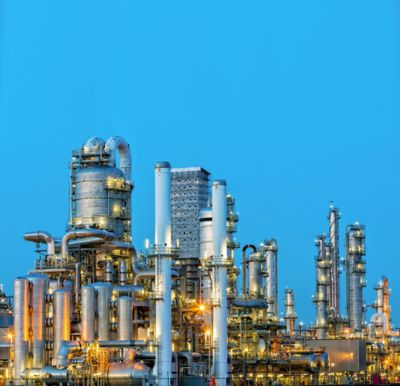 A large, modern petrochemical plant at dusk in industrial district near Rotterdam, Netherlands, Benelux, Europe. Many chimneys, tanks, distillation towers and other installations are visible against blue sky. 50 megapixel HDR image taken with Canon EOS 5Ds, digital blending technique, long exposure with tripod.