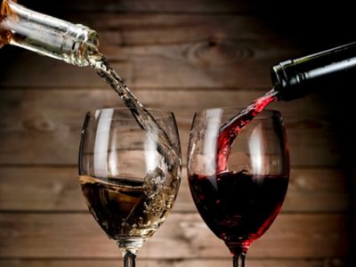 Red and white wine pouring on wood background