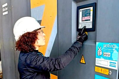 a woman at work, she is a technician and she is checking the screen of a compressor