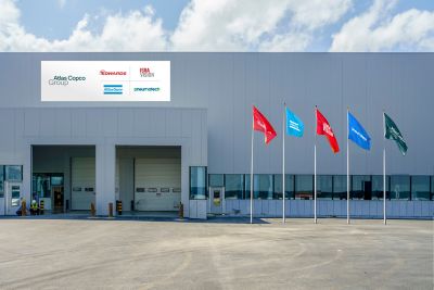 Facade of a facility showing logotypes of Group and other Group brands on the facade and on flags