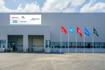 Facade of a facility showing logotypes of Group and other Group brands on the facade and on flags