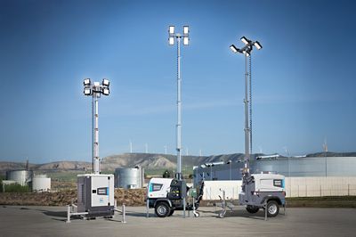 Atlas copco's Hybrid light tower with mast-mounted LED floodlights operating at an industrial facility during daylight.