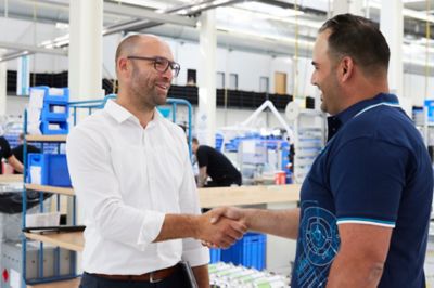 Atlas Copco Service representative and customer handshaking in the production site