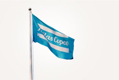 An Atlas Copco flag blowing in the wind