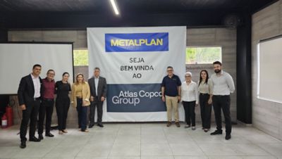9 pessoas em frente a um banner de boas vindas