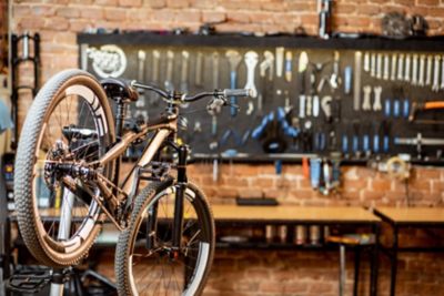 Mountain bicycle during the repairing process hanging on the stand at the workshop