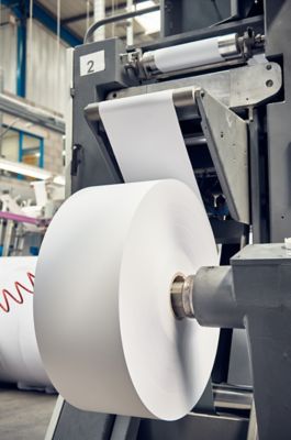 A toilet paper making machine, producing toilet and bathroom paper rolls due to Corona virus panic buying.  Paper and tissue manufacturers factory and engineered machinery. 