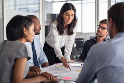 Team of employees in a conference room working on blueprint..