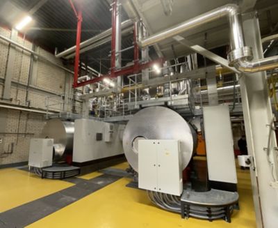 Industrielle Hybridkesselanlage, umgeben von Edelstahlrohren, Kabelkanälen und Schaltschränken