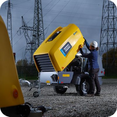 Atlas Copco employee working with a mobile air compressor